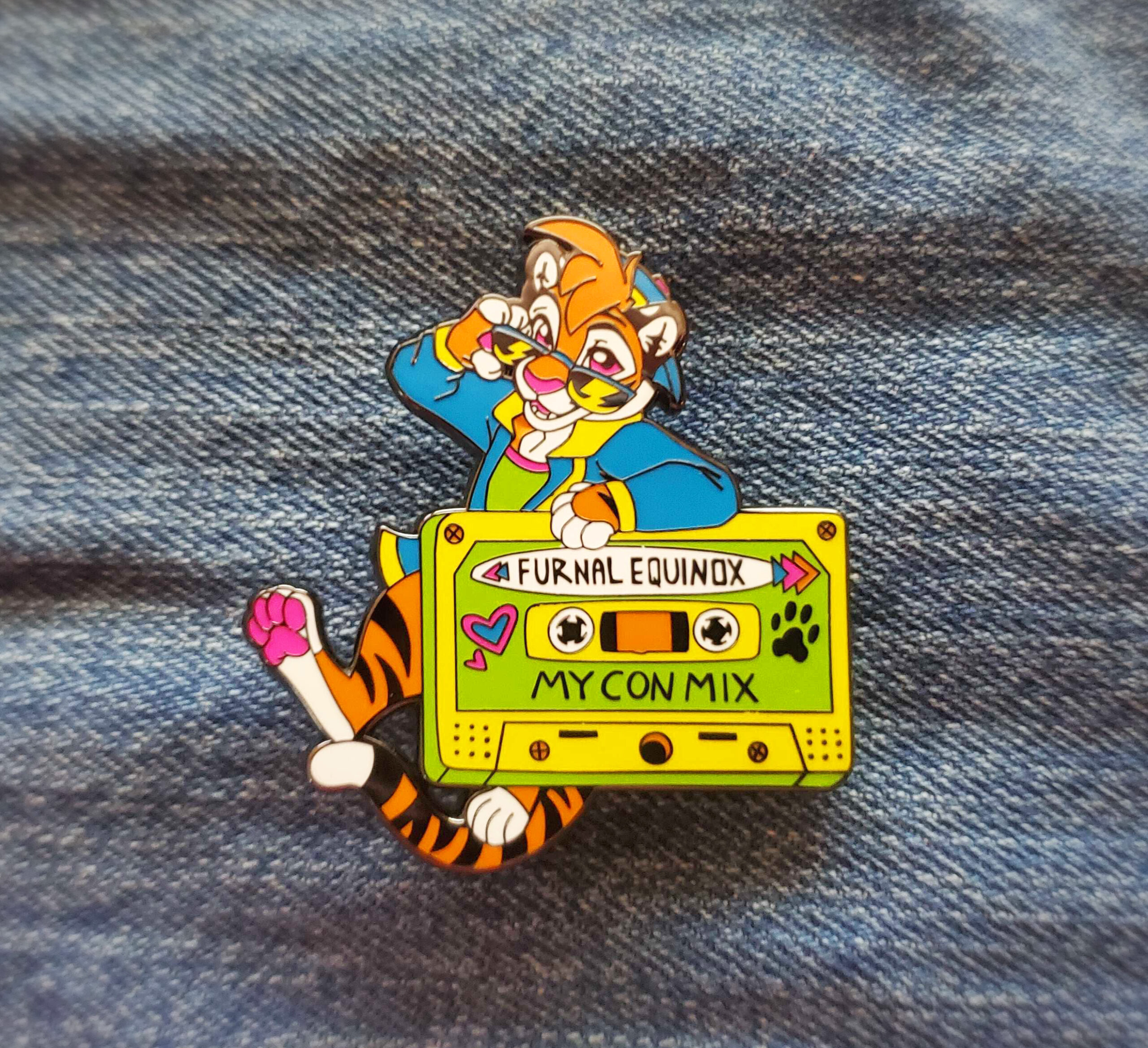 pin2 A close up of a hand holding the hard enamel pin. it's that features a lynx riding a skateboard with the inscription FE 2020.